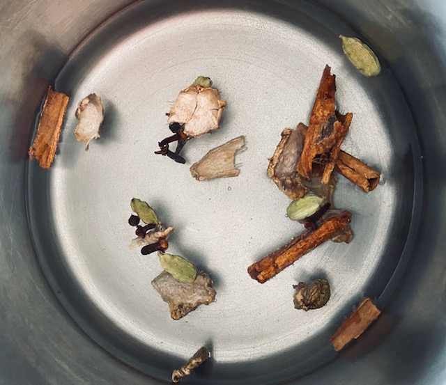 Epices du thé chai Massala dans l'eau frémissante
