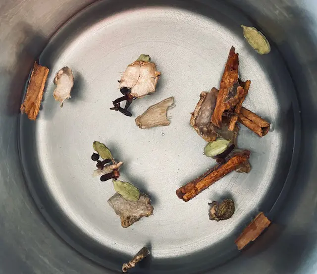 Epices du thé chai Massala dans l'eau frémissante