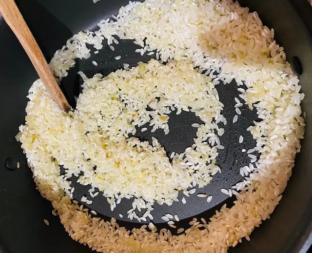 Riz mis à revenir dans la poêle avec les oignons